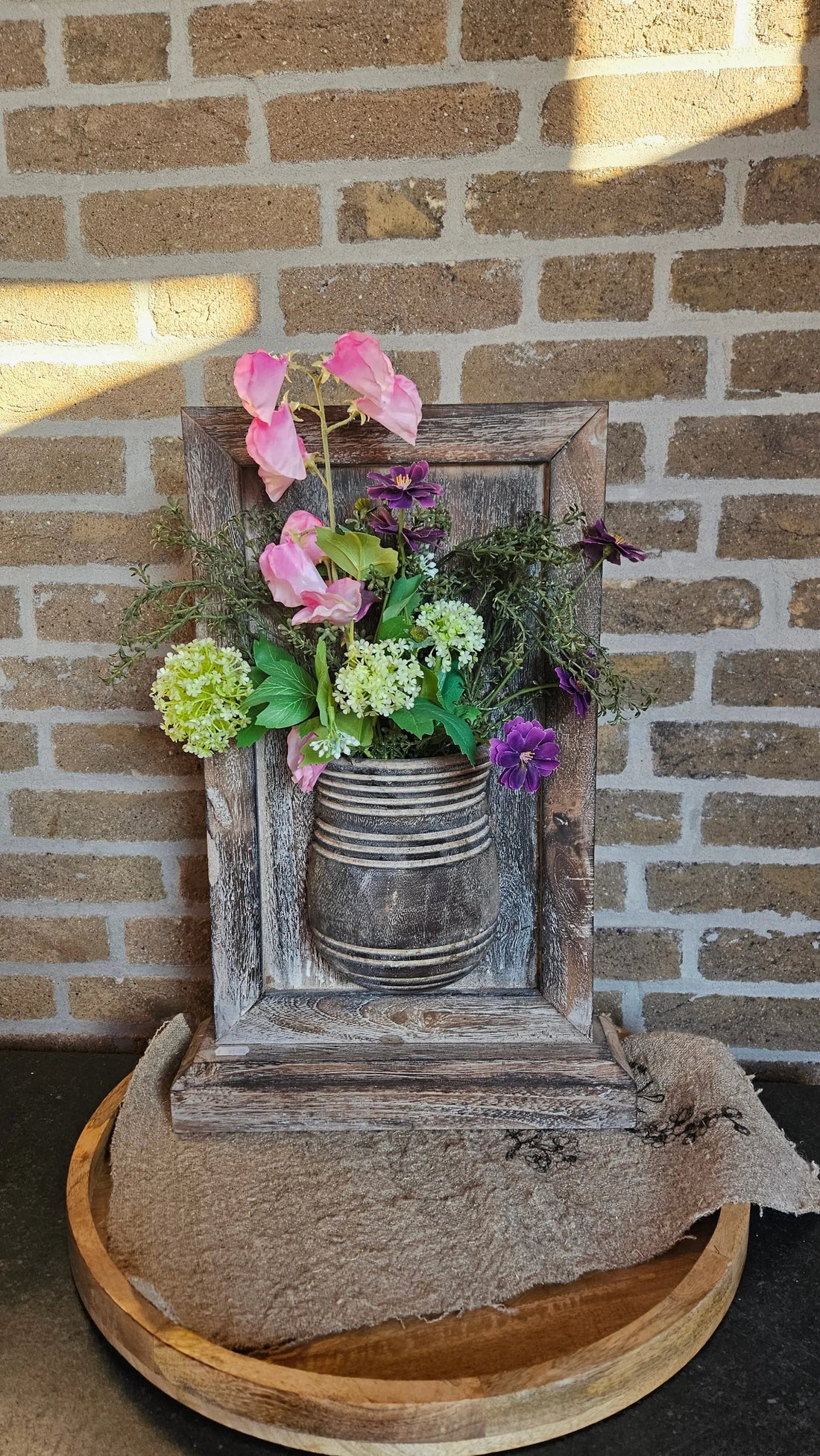 Houten wandbord met zijden bloemen als warme houten decoratie in huis